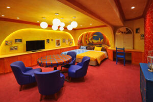 色彩缤纷的客房，配有床、桌子和蓝色椅子