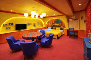 色彩缤纷的客房，配有圆桌、椅子和床铺