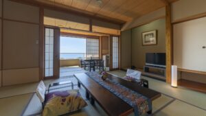 Chambre tatami avec table basse et coin salon face à l’océan
