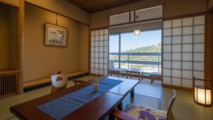 Chambre en tatami avec table basse et banquette près de la fenêtre