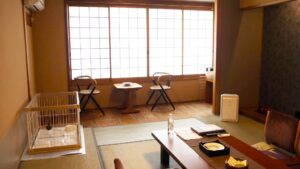 Chambre en tatami avec table basse et coin salon près de la fenêtre