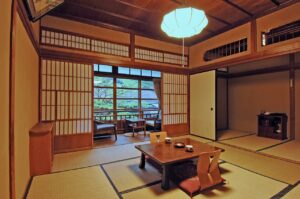 Tatami-Zimmer mit niedrigem Tisch und Stühlen am Fenster