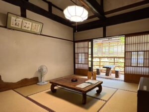 Tatamizimmer mit niedrigem Tisch und Sitzbereich am Fenster