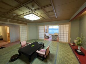 Habitación de tatami con mesa baja y zona de asientos junto a la ventana