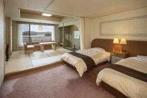 Camas individuales junto a una zona de estar de tatami con vista por la ventana