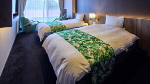 客房内配有绿色床尾巾的双床