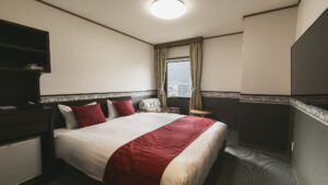 Double bed with red runner in guest room