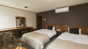 Twin beds in a guest room with desk and chair