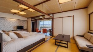Chambre avec lits, canapé, table et vue par la fenêtre