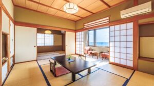 Chambre en tatami avec table basse et coin salon près de la fenêtre