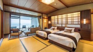 Lits jumeaux dans une chambre en tatami avec coin salon face à l’océan