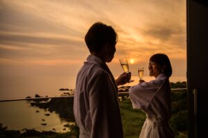 Deux personnes portent un toast sur un balcon au coucher du soleil