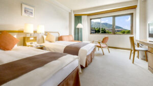 山の景色を望む客室のツインベッド