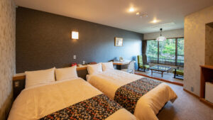 窓際のシーティングがある客室のツインベッド