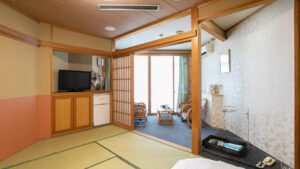 Chambre en tatami avec chaises, table et télévision
