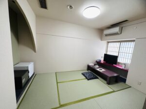 Chambre en tatami avec table basse, coussin de sol et télévision