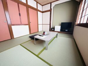 Chambre en tatami avec table basse, coussin de sol et télévision