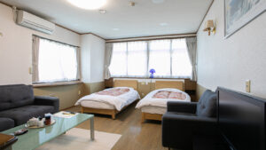 Lits jumeaux dans une chambre avec canapés et table