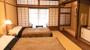 Habitación de tatami con dos camas bajas y asiento junto a la ventana