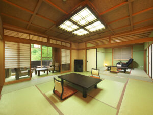 Chambre en tatami avec table basse, chaises et coin salon