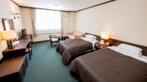 Lits jumeaux dans une chambre avec bureau et chaises