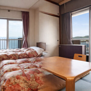 Futons à côté d’une table basse et de fenêtres avec vue sur l’océan