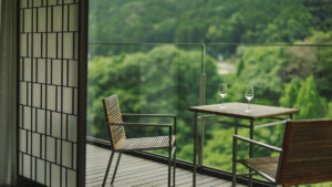 Balcony table and chairs overlooking green forest