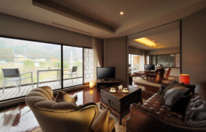 Living area with armchairs, sofa, and balcony view