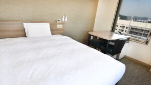 Letto accanto a un tavolino e a una finestra
