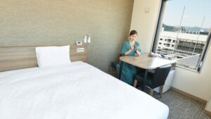 Letto accanto al tavolo vicino alla finestra con una donna seduta