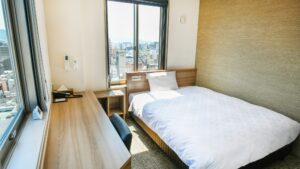 Letto singolo accanto alla scrivania e alla finestra nella camera