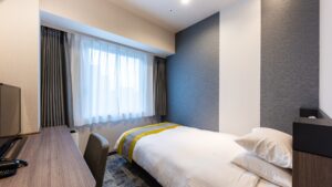 Single bed beside a window in a guest room