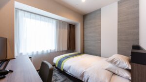 Single bed beside a window in a guest room