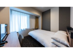 Single bed beside window and desk in guest room