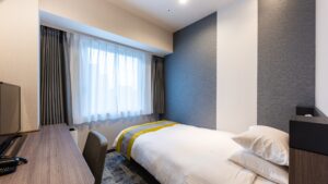 Single bed beside window in guest room