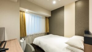 Twin beds beside a window in a guest room