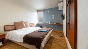 Doppelbett im Gästezimmer mit Schreibtisch und Fenster