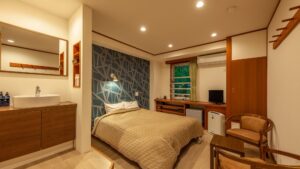 Bedroom with double bed, sink, and chair
