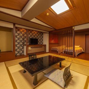 Tatami room with low table, floor chairs, and beds