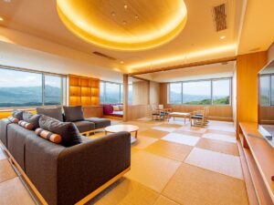 Camera con tatami, divani, sedie e grandi finestre