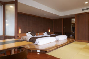 Letti singoli accanto a una zona salotto con tatami