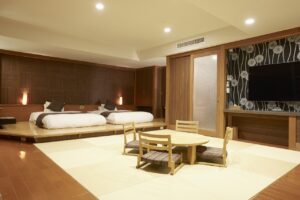 Letti singoli accanto a una zona salotto con tatami