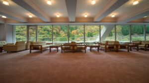 Ampia lounge con divani e grandi finestre affacciate sugli alberi