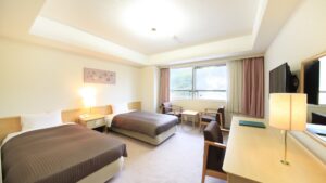 테이블과 의자가 있는 객실의 트윈 베드