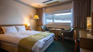 Bett am Fenster mit zwei Stühlen und Tisch