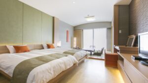 Zwei Einzelbetten in einem hellen Ryokan-Gästezimmer