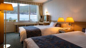 Zwei Einzelbetten in einem Gästezimmer mit Seeblick