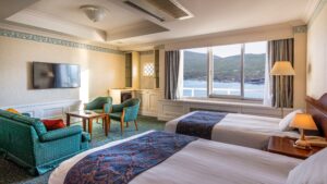 Zwei Einzelbetten im Gästezimmer mit Stühlen und Seeblick