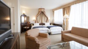 Zwei Betten mit Sofa und Stühlen im Gästezimmer