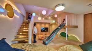 계단과 미끄럼틀이 있는 패밀리룸 실내 모습과 사람들